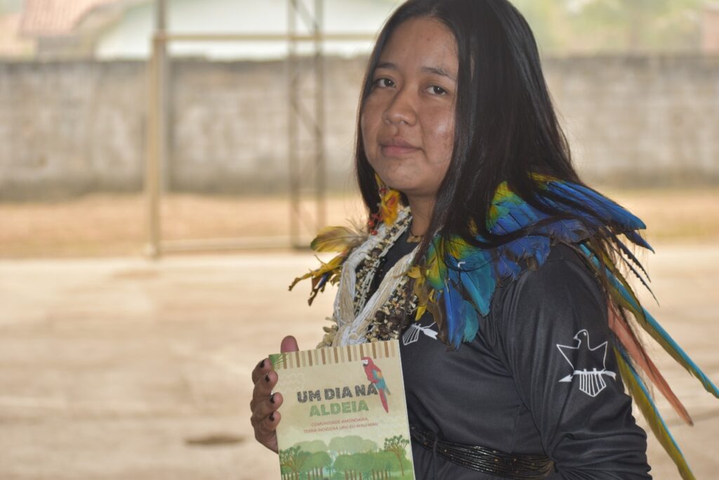 Baina Amondawa segura o livro lançado por Apia e Opi com apoio da Coiab.