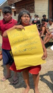 Maria Manchineri segura cartaz em protesto por melhorias na educação indígena.