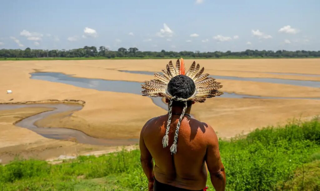 Indígena contempla a seca extrema no rio Negro, no Amazonas